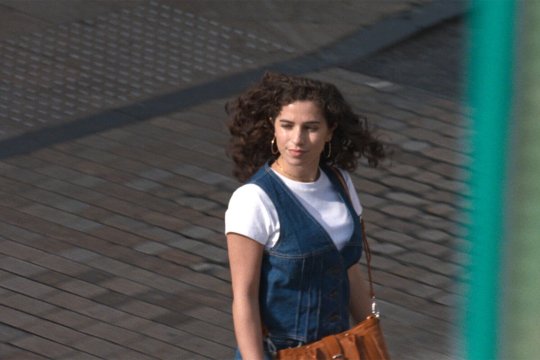 woman in a jeansdress crossing a street
